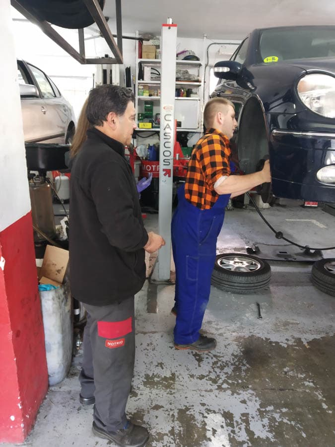 Mechanics changing wheels in car